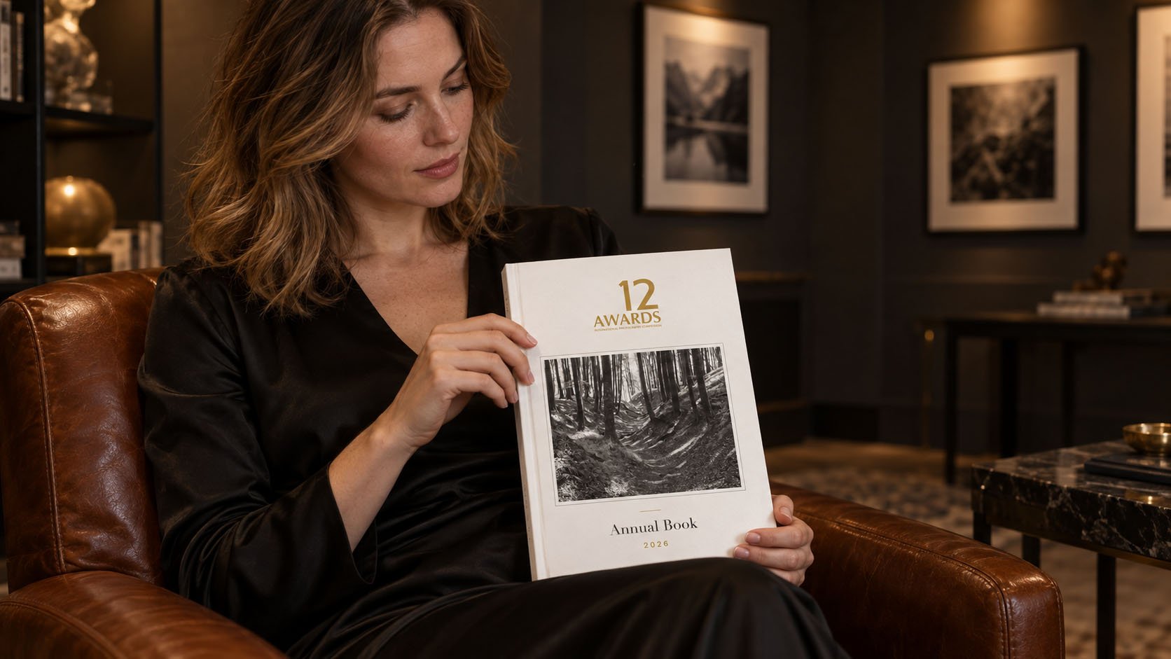 A reader holding the 12AWARDS Annual Book 2026